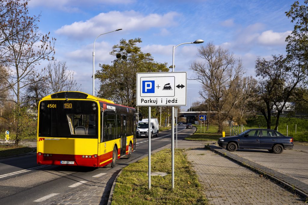 zdjęcie przedstawia autobus podmiejski i znak informujący o parkingu typu "parkuj i jedź"